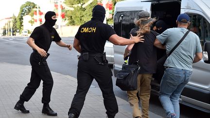 Les policiers anti-émeutes arrêtent un homme lors d'un rassemblement de l'opposition à la veille de l'élection présidentielle, le 8 août 2020, à Minsk, en Biélorussie. (SERGEI GAPON / AFP)