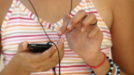 Adolescente écoutant de la musique sur son smartphone (photo d'illustration) (UIG VIA GETTY IMAGES)