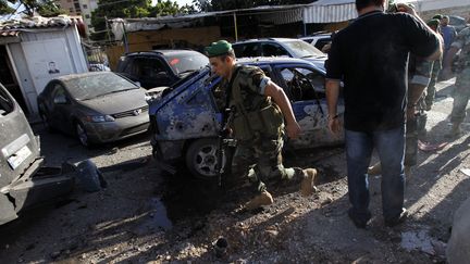 Les forces de s&eacute;curt&eacute;s libanaises inspectent l'une des deux zones touch&eacute;es par des roquettes dimanche 26 mai 2013, dans le sud de Beyrouth (Liban). (ANWAR AMRO / AFP)