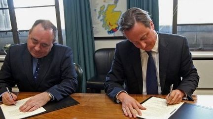 David Cameron et Alex Salmond signent l'accord de référendum. (AFP)