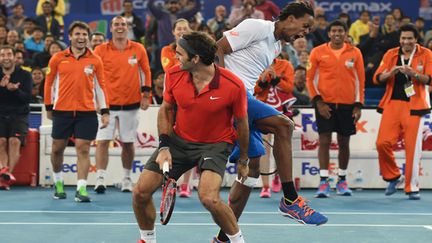 Adversaires il y a moins d'un mois en finale de Coupe Davis, Gaël Monfils et Roger Federer s'amusent en double à l'IPTL. (SAJJAD HUSSAIN / AFP)