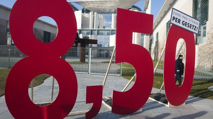 Un panneau r&eacute;clamant 8,50 euros de l'heure de salaire minimum, devant la Chancellerie, &agrave; Berlin (Allemagne), le&nbsp;23 f&eacute;vrier 2011.&nbsp; (JOHN MACDOUGALL / AFP)