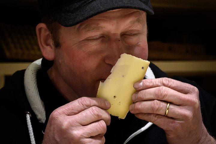 M. Beate Wampfler, fromager-affineur à Berthoud (Suisse), goûte ses meules d'emmental amoureusement affinées en musique, le 14 mars 2019.
 (Fabrice Coffrini/ AFP)