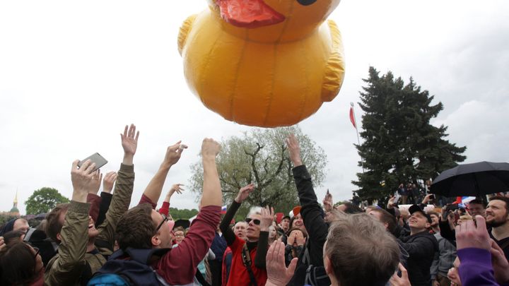 Des manifestants réunis à Saint-Pétersbourg (Russie), le 12 juin 2017, s'amusent avec un canard gonflable, devenu un symbole de la lutte anticorruption en Russie après une enquête d'Alexeï Navalny. (SERGEY MIHAILICENKO / ANADOLU AGENCY / AFP)