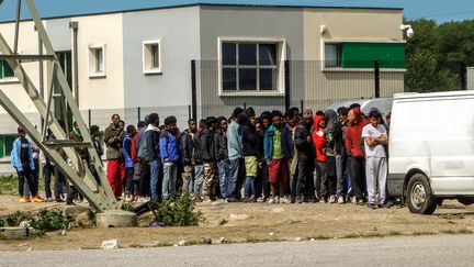 A Calais, des migrants font la queue devant un camion pour recevoir de la nourriture, le 4 août 2017. (PHILIPPE HUGUEN / AFP)