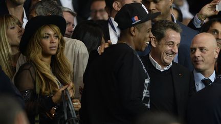 L'ancien pr&eacute;sident de la R&eacute;publique Nicolas Sarkozy, le 30 septembre 2014 au Parc des Princes, avec Jay-Z (au centre) et Beyonce (&agrave; gauche). (FRANCK FIFE / AFP)