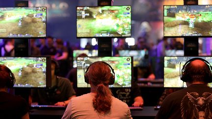 Des visiteurs du salon Gamescom jouent au jeu&nbsp;World of Warcraft à Cologne en Allemagne le 21 août 2018.&nbsp; (OLIVER BERG / DPA /AFP)