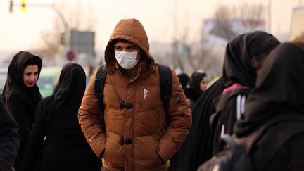 Un homme portant un masque anti-pollution dans les rues de Téhéran (Iran), le 19 décembre 2015. (ATTA KENARE / AFP)