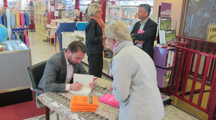 Laurent Obertone d&eacute;dicace son livre "La France Big Brother" &agrave; Carpentras (Vaucluse), le 10 avril 2015. Au second plan, &agrave; droite, le conseiller d&eacute;partemental&nbsp;FN Herv&eacute; de L&eacute;pinau. (ARIANE NICOLAS / FRANCETV INFO)