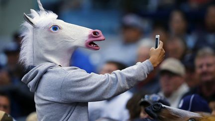 Un supporter de baseball masqu&eacute; se prend en photo dans les gradins lors d'un match opposant les San Diego Padres aux Toronto Blue Jays &agrave; San Diego (Californie), le 2 juin 2013. (MIKE BLAKE / REUTERS)