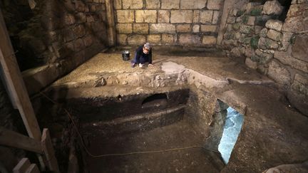 L'archéologue israélienne Tehila Sadiel travaille dans l'une des pièces souterraines mises au jour à Jérusalem, non loin du Mur des Lamentations, le 19 mai 2020 (MENAHEM KAHANA / AFP)