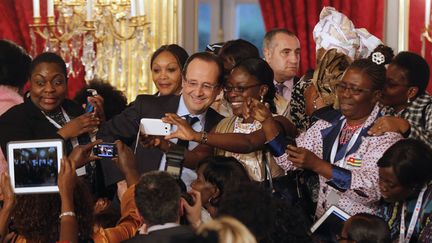 Le pr&eacute;sident fran&ccedil;ais, Fran&ccedil;ois Hollande, pose avec des participantes au&nbsp;Forum mondial des femmes francophones, &agrave; l'Elys&eacute;e (Paris), le 20 mars 2013. (PIERRE VERDY / AFP)