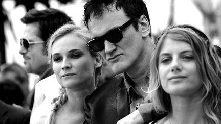 Quentin Tarantino pose avec les actrices du film Inglorious Basterds,&nbsp;Diane Kruger et Mélanie Laurent.&nbsp;Il est présenté en compétition et fera sensation sur la Croisestte. Un film qui permettra à&nbsp;Christoph Waltz de remporter le&nbsp;prix d'interprétation masculine. (ANNE-CHRISTINE POUJOULAT / AFP)