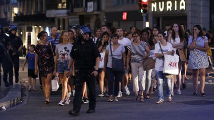 Des policiers évacuent des riverains et des touristes après l'attentat de Barcelone (Espagne), le 17 août 2017. (PAU BARRENA / AFP)