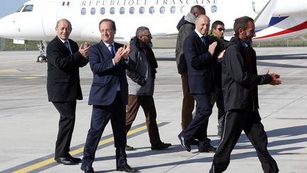 De gauche &agrave; droite, le ministre de la D&eacute;fense Jean-Yves Le Drian, le pr&eacute;sident Fran&ccedil;ois Hollande et le ministre des Affaires &eacute;trang&egrave;res Laurent Fabius, entour&eacute;s des otages lib&eacute;r&eacute;s au Niger, le 30 octobre 2013 &agrave; Villacoublay. (FRANCOIS GUILLOT / AFP)