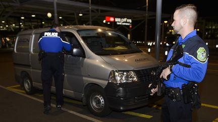 Des policiers contr&ocirc;lent un v&eacute;hicule &agrave; l'a&eacute;roport de Gen&egrave;ve, le 10 d&eacute;cembre 2015. (RICHARD JUILLIART / AFP)