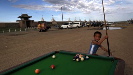 Un jeune gar&ccedil;on joue au billard devant un monast&egrave;re &agrave; Karakorum (Mongolie), le 7 juillet 2012. (HOW HWEE YOUNG / EPA / MAXPPP)