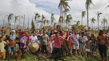 Des survivants du typhon Haiyan attendent que se pose un h&eacute;licopt&egrave;re rempli de vivres &agrave; Tacloban (Philippines), le 17 novembre 2013. (DAMIR SAGOLJ / REUTERS)