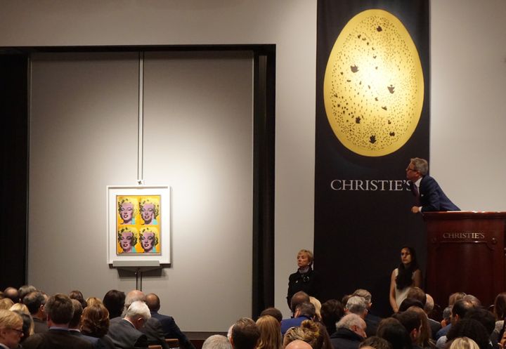 Deux autres moments clé des enchères chez Christie's du 10 novembre :  la toile de Warhol, "Four  Marylins" (à gauche), ainsi que "Concetto spaziale, La fine di Dio" de Lucio Fontana (à droite, en forme d'oeuf).
 (Selcuk Acar / ANADOLU AGENCY)