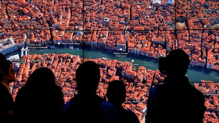 Des personnes regardant Venise sur Google Earth alors que Google Earth dévoilait une nouvelle version de l'application, le 18 avril 2017 lors d'un événement au Whitney Museum of Art de New York (TIMOTHY A. CLARY / AFP)