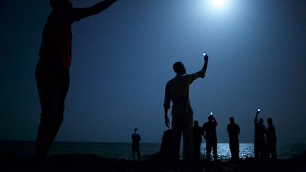 World Press Photo de l'ann&eacute;e : Des migrants africains brandissent leurs t&eacute;l&eacute;phones sur une plage de Djibouti, f&eacute;vrier 2013. (JOHN STANMEYER / VII FOR NATIONAL GEOGRAPHIC)