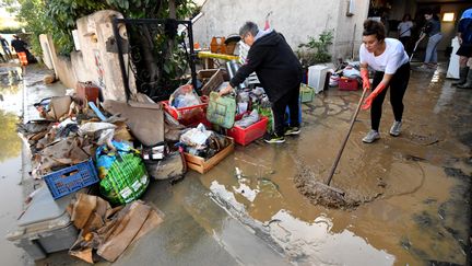 Des habitants nettoient leur maison après&nbsp;les&nbsp;forts orages à&nbsp;Villeneuve-lès-Beziers (Hérault). (PASCAL GUYOT / AFP)