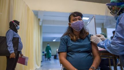 Une femme enceinte reçoit le vaccin&nbsp;Sinovac, le 19 août 2022, à&nbsp;Surabaya en Indonésie. (JUNI KRISWANTO / AFP)