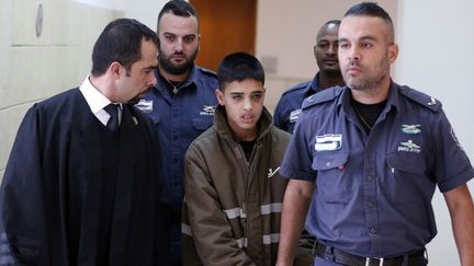 Un Palestinien de 13 ans accusé d'avoir poignardé de deux Israéliens, est escorté par la sécurité israélienne lors d'une audience devant un tribunal de Jérusalem le 30 octobre 2015.  (Ahmad Gharabli / AFP)