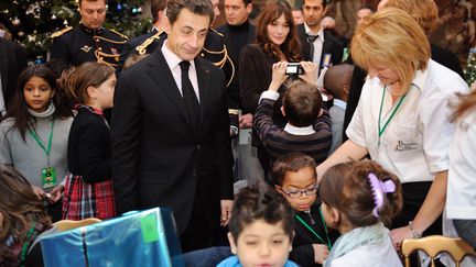 Nicolas Sarkozy, le 15 d&eacute;cembre 2010, tandis que Carla Bruni-Sarkozy pose pour une photo. (ERIC FEFERBERG / POOL)