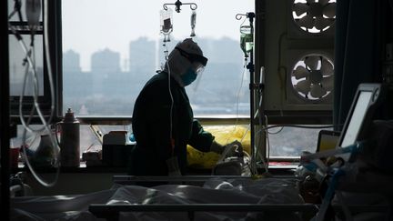 Un membre du personnel soignant d'un hôpital de Wuhan (Chine) s'occupe d'un malade à l'isolement en pleine épidémie de coronavirus, le 22 février 2020. (CHINA DAILY CDIC / REUTERS)