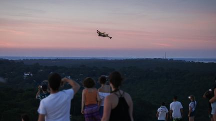 Un Canadair survolant la Dune du Pilat, dans les environs de La Teste-de-Buch (Gironde), le 14 juillet 2022. (THIBAUD MORITZ / AFP)