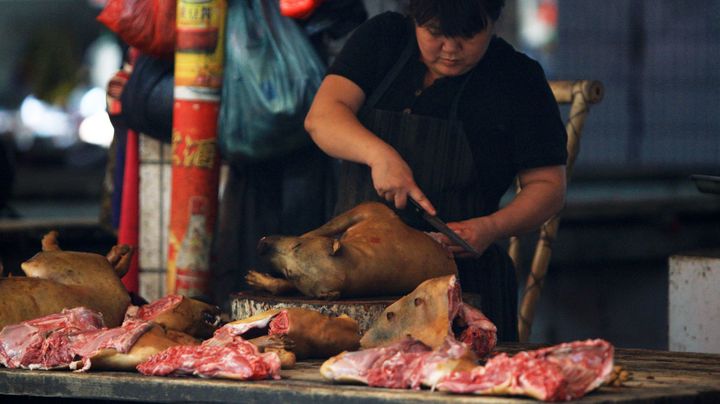 Une femme coupe de la viande de chien disponible &agrave; la vente sur le march&eacute; de Yulin (Chine), le 18 juin 2014. (AFP)