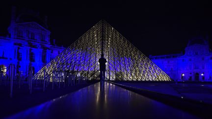 Le musée du Louvre, à Paris, éclairé aux couleurs de l'Union européenne (1er janvier 2022) (JULIEN DE ROSA / AFP)