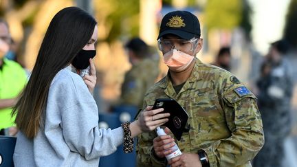 Un membre des Forces de défense australiennes&nbsp;(ADF) oriente une jeune fille au centre de vaccination de Qudos Bank Arena, à Sydney, le 16 août 2021. (BIANCA DE MARCHI / AAP)