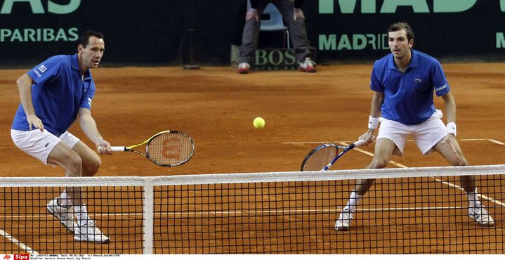 Le tennisman français Michaël Llodra (à gauche) au filet, en compagnie de son partenaire Julien Benneteau, le 5 mars 2011, dans un hangar de l'aéroport de Vienne (Autriche). (RONALD ZAK/AP/SIPA / AP)