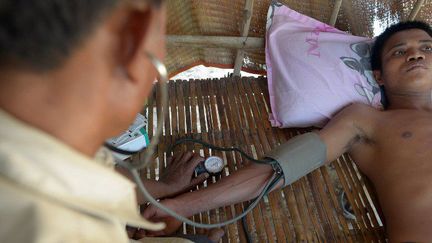 Ken Mon, médecin cambodgien non-diplômé, examine un patient dans un village dans la province de Kampong Speu. (AFP PHOTO / TANG CHHIN SOTHY)