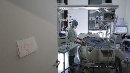 Un soignant prend en charge un patient atteint de Covid-19, le 22 avril 2021, à l'hôpital Pasteur de Colmar (Haut-Rhin). (SEBASTIEN BOZON / AFP)