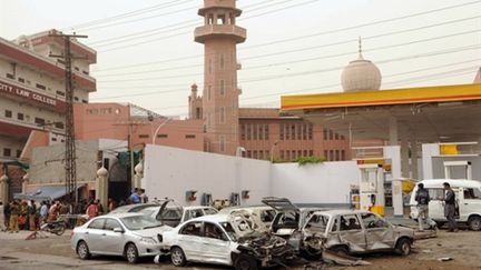 Des policiers rassemblés à l'extérieur d'une des mosquées où s'est déroulée la fusillade, à Lahore, le 28/05/10 (AFP/Arif Ali)