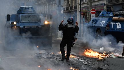 Un membre des forces de l’ordre donne des instructions aux véhicules blindés de la Gendarmerie sur ce qui ressemble à une scène de chaos à Paris, le 8 décembre 2018.&nbsp; (BERTRAND GUAY / AFP)