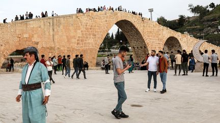 Des touristes au pont Abbasside dans le Kurdistan, au nord de l'Irak, en avril 2023. (SAFIN HAMID / AFP)