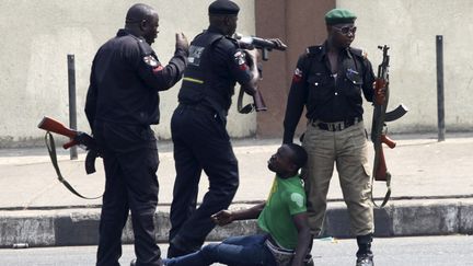 Des policiers frappent un homme lors d'une manifestation pour protester contre la hausse des prix de l'essence &agrave; Lagos (Nig&eacute;ria), le 3 janvier 2012. (AKINTUNDE AKINLEYE / REUTERS)