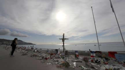 Une femme rend hommage aux victimes des attentats à Nice (Alpes-Maritimes), le 16 octobre 2016. (VALERY HACHE / AFP)