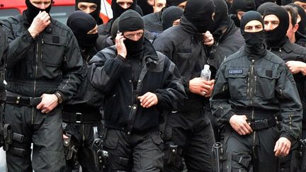 Des hommes du Raid quittent le quartier de la C&ocirc;t&eacute; pav&eacute;e, &agrave; Toulouse (Haute-Garonne),&nbsp;o&ugrave; &eacute;tait situ&eacute; l'appartement de Mohamed Merah, le 22 mars 2012. (PASCAL PAVANI / AFP)