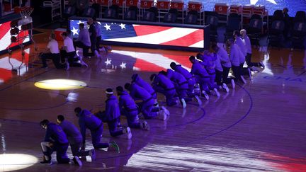 Les joueurs de l'équipe des Clippers s'agenouillent pendant l'hymne national, avant leur match NBA à San Francisco (Californie, Etats-Unis), le 6 janvier 2021, en réaction à la manifestation violente des partisans de Donald Trump à Washington. (EZRA SHAW / GETTY IMAGES NORTH AMERICA / AFP)