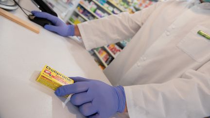 Un pharmacien vend une boîte de Doliprane, le 24 mars 2020 à Excideuil (Dordogne). (ROMAIN LONGIERAS / HANS LUCAS / AFP)