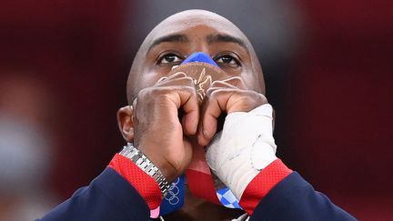 Teddy Riner savoure sa médaille de bronze, conquise à Tokyo le 30 juillet 2021, sa quatrième médaille olympique en carrière. (FRANCK FIFE / AFP)