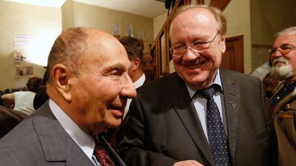 Serge Dassault (à gauche), ancien maire de Corbeil-Essonnes décédé en 2018, et l'actuel maire de la commune Jean-Pierre Bechter, le 13 mars 2014. (FRANCOIS GUILLOT / AFP)