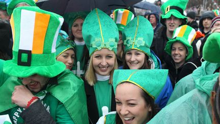 Des jeunes filles arborent une mitre verte en hommage &agrave; Saint-Patrick dans le d&eacute;fil&eacute; de Dublin (Irlande), auquel participent pr&egrave;s de 600 000 personnes, le 17 mars 2013. (PETER MUHLY / AFP)