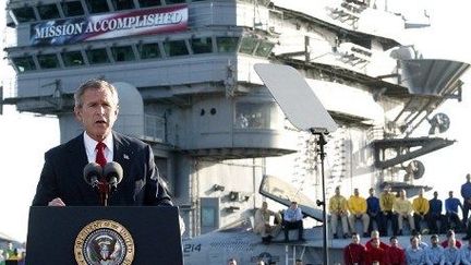 George Bush, le 1er mai 2003, sur le pont de l'«Abraham Lincoln» sous la banderole «Mission accomplie». Le président américain annonce la fin des combats en Irak. (STEPHEN JAFFE / AFP)