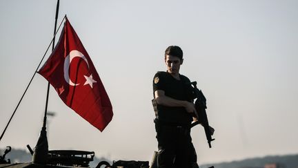 Un policier turc d'une unité anti-émeute se tient sur un tank après la&nbsp;tentative de putsch, le 16 juillet 2016. (OZAN KOSE / AFP)